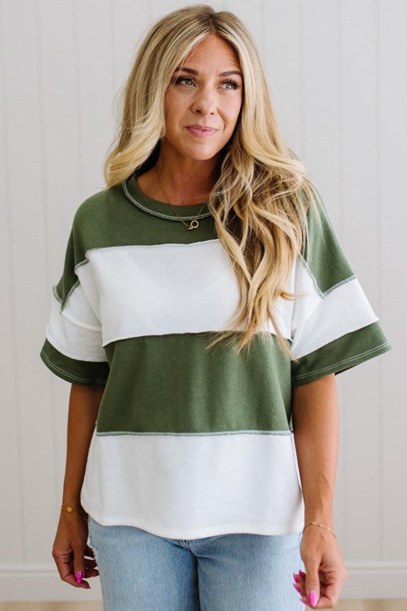 Woman wearing a green and white striped shirt with a neutral background