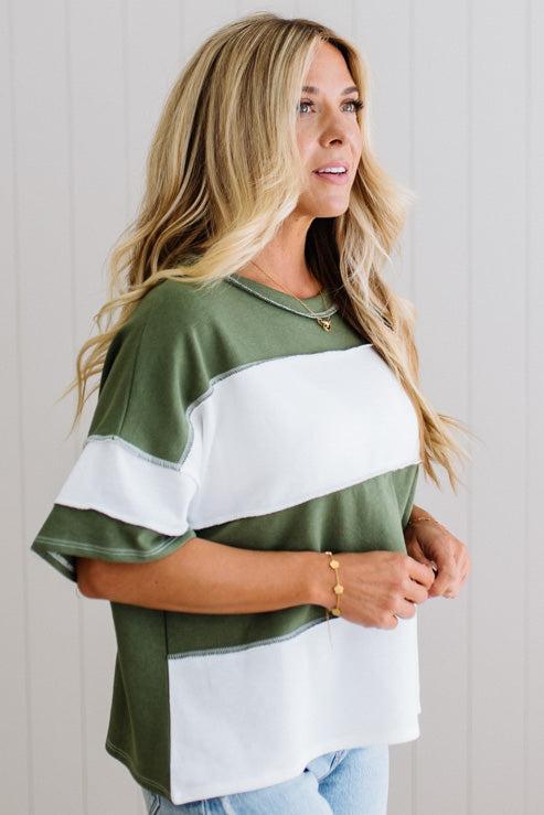 Woman wearing a green and white striped shirt against a plain background