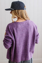 BLONDE WOMAN WEARING A COZY RIBBED TEXTURE CARDIGAN WITH SHELL BUTTONS AND A POLKA DOT HAT.