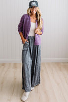 BLONDE WOMAN WEARING A COZY RIBBED TEXTURE CARDIGAN WITH SHELL BUTTONS AND A POLKA DOT HAT.