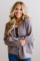 BLONDE WOMAN WEARING A COZY RIBBED TEXTURE CARDIGAN WITH SHELL BUTTONS AND A NECKLACE
