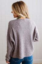 BLONDE WOMAN WEARING A COZY RIBBED TEXTURE CARDIGAN WITH SHELL BUTTONS AND A NECKLACE