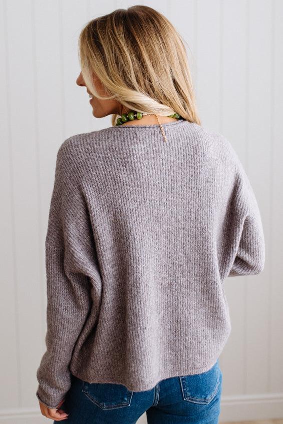 BLONDE WOMAN WEARING A COZY RIBBED TEXTURE CARDIGAN WITH SHELL BUTTONS AND A NECKLACE