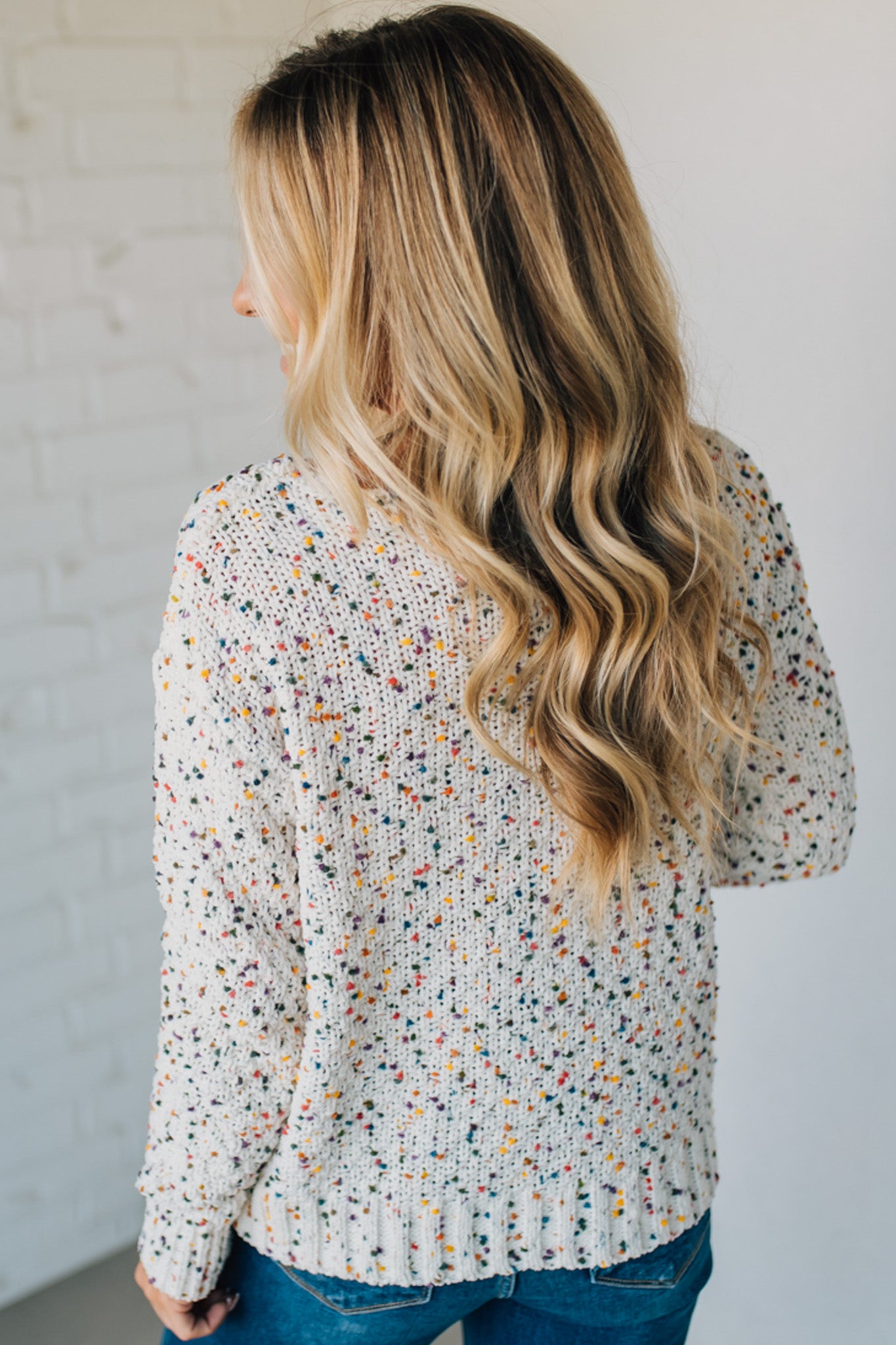 Woman wearing a patterned blouse with a neutral background