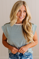 Woman wearing a striped shirt and jeans against a neutral background