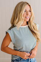 Woman wearing a black and white striped top against a beige background