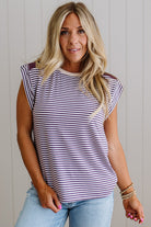 Woman wearing a striped shirt and jeans against a plain background