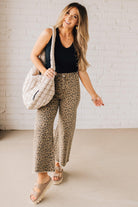 BLONDE WOMAN WEARING MID RISE LEOPARD TWILL DENIM FRAYED HEM WIDE LEG PANTS.