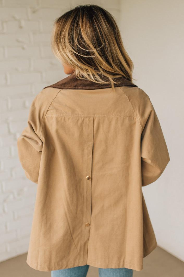 Person wearing a beige jacket with a white background