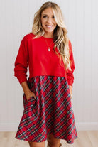 Blonde woman wearing a knee length dress with red french terry top, and red plaid skirt bottom with pockets on the sides.