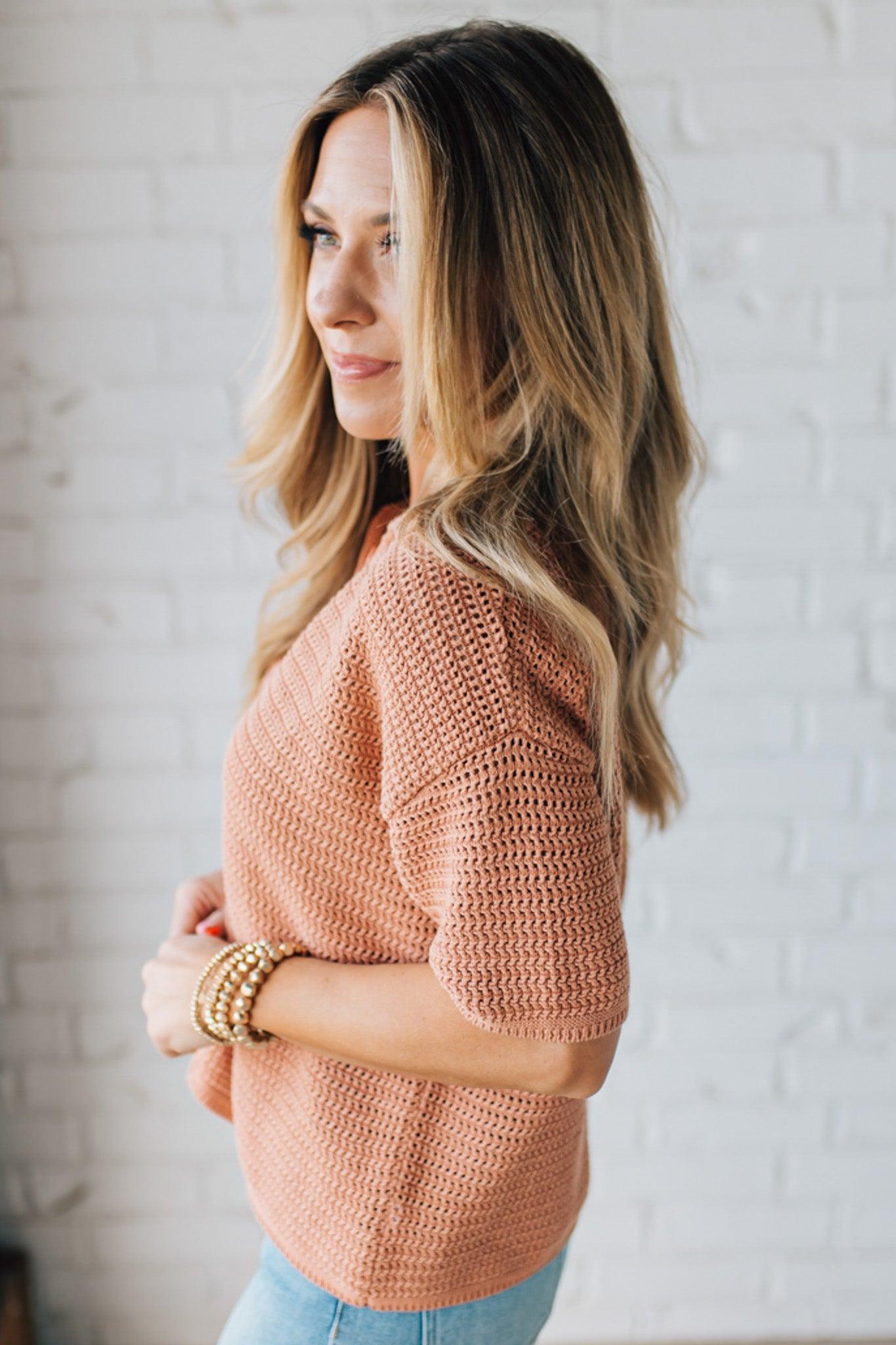 Blonde Woman Wearing a Boxy Crochet Button Up Sweater Shirt in the Color Dusty Peach.