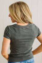 Woman wearing a gray t-shirt with a plain background