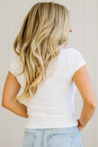 Person wearing a white t-shirt and light blue jeans with long blonde hair.