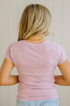 Person wearing a pink t-shirt with a neutral background