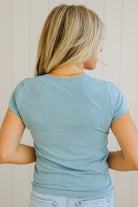 Person wearing a light blue t-shirt against a neutral background