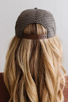 Blonde smiling woman wearing a plaid hat with a brown rope across the front, and a patch that is cream with brown embroidery that says Days Like These.