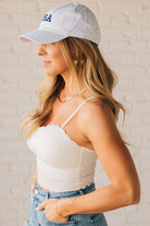 Blonde Woman Wearing a Seamless Lace Bralette With Bra Pads with Ribbed Texture and Eyelet Lace.