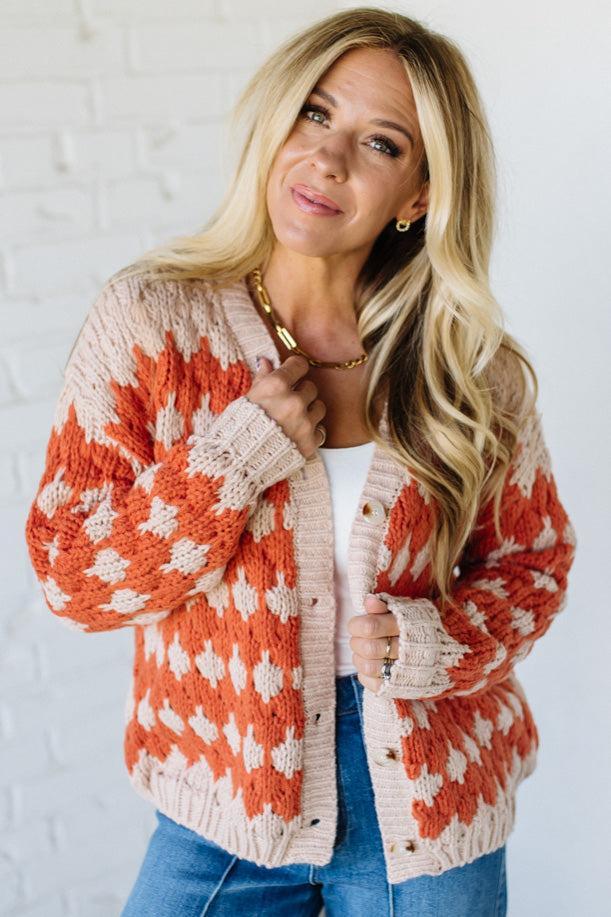 Woman wearing a patterned cardigan against a white background