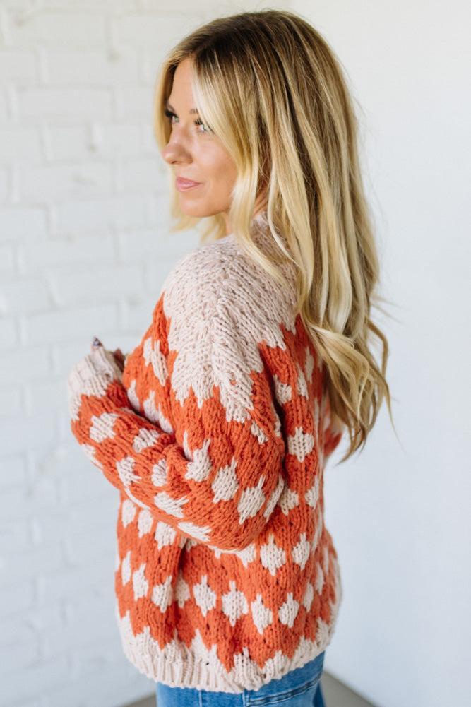 Woman wearing a patterned sweater against a white background