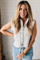 BLONDE WOMAN WEARING A DITSY FLORAL PRINT SCALLOP EDGE DETAILED DENIM CROP VEST.
