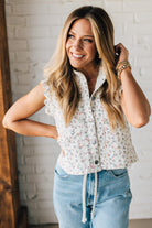 BLONDE WOMAN WEARING A DITSY FLORAL PRINT SCALLOP EDGE DETAILED DENIM CROP VEST.
