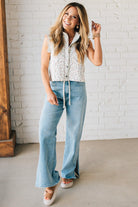 BLONDE WOMAN WEARING A DITSY FLORAL PRINT SCALLOP EDGE DETAILED DENIM CROP VEST.