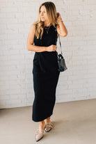Blonde woman in a black dress with a Convertible Woven Crossbody Handbag in balck vegan leather.