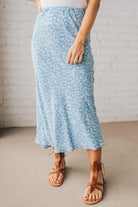 Blonde woman wearing a floral lightweight midi skirt.