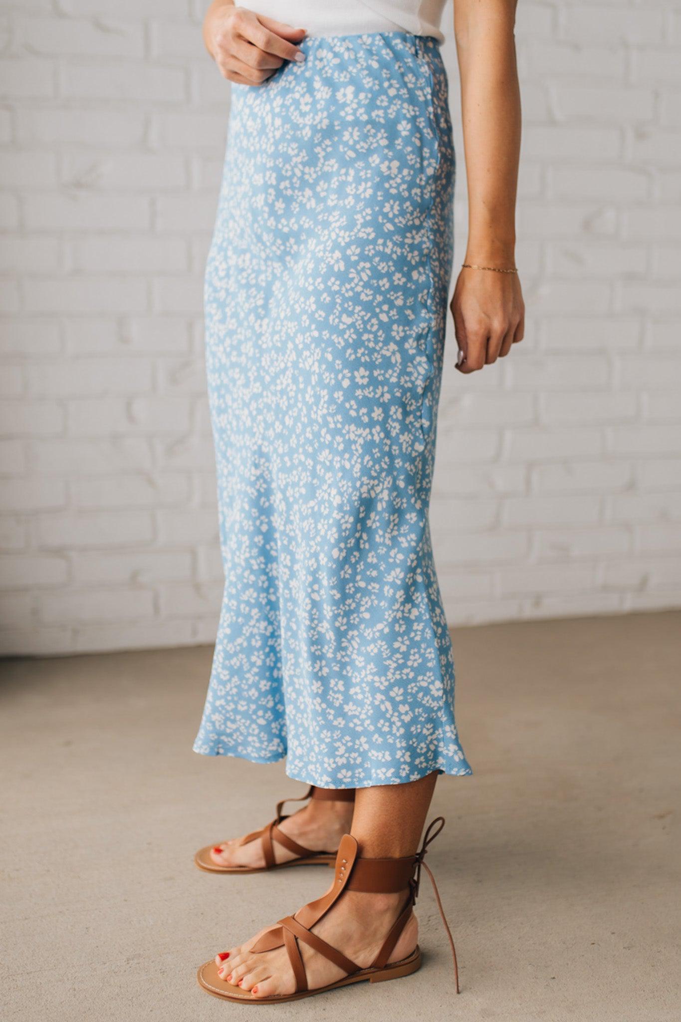 Blonde woman wearing a floral lightweight midi skirt.