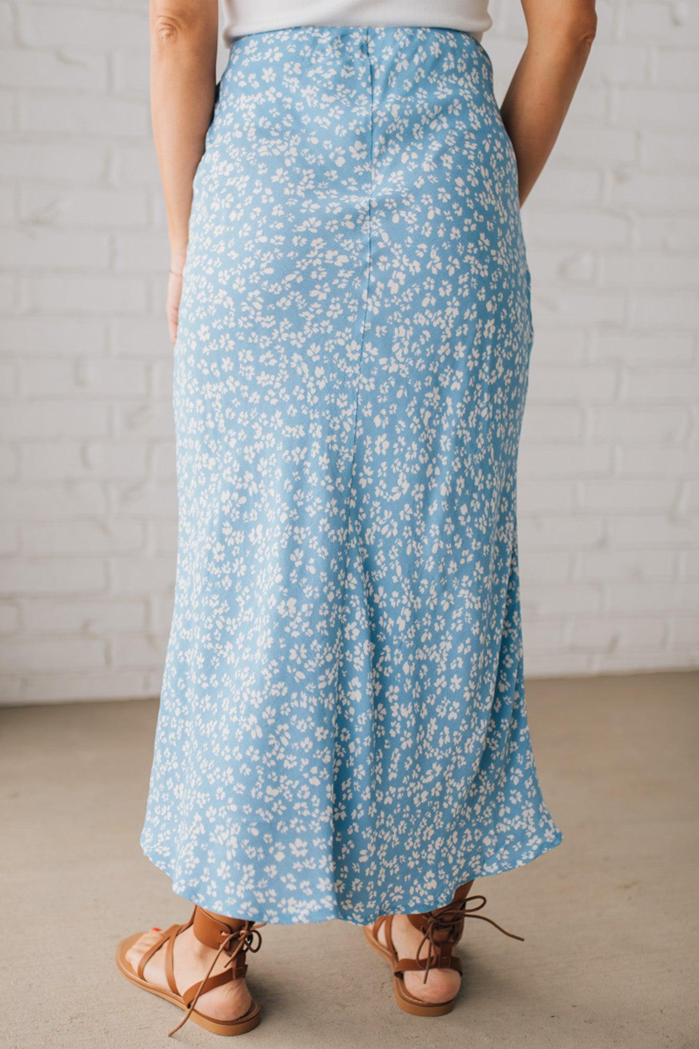 Blonde woman wearing a floral lightweight midi skirt.