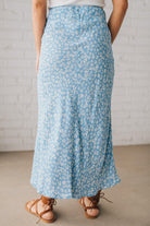 Blonde woman wearing a floral lightweight midi skirt.