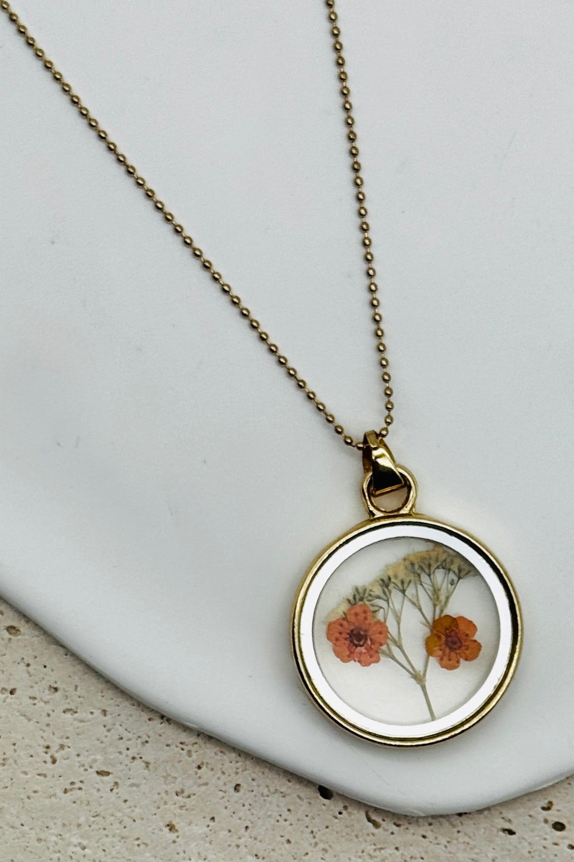 Double Sided Dry Flower Pendant Necklace with mini orange flowers inside.