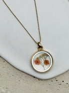 Double Sided Dry Flower Pendant Necklace with mini orange flowers inside.