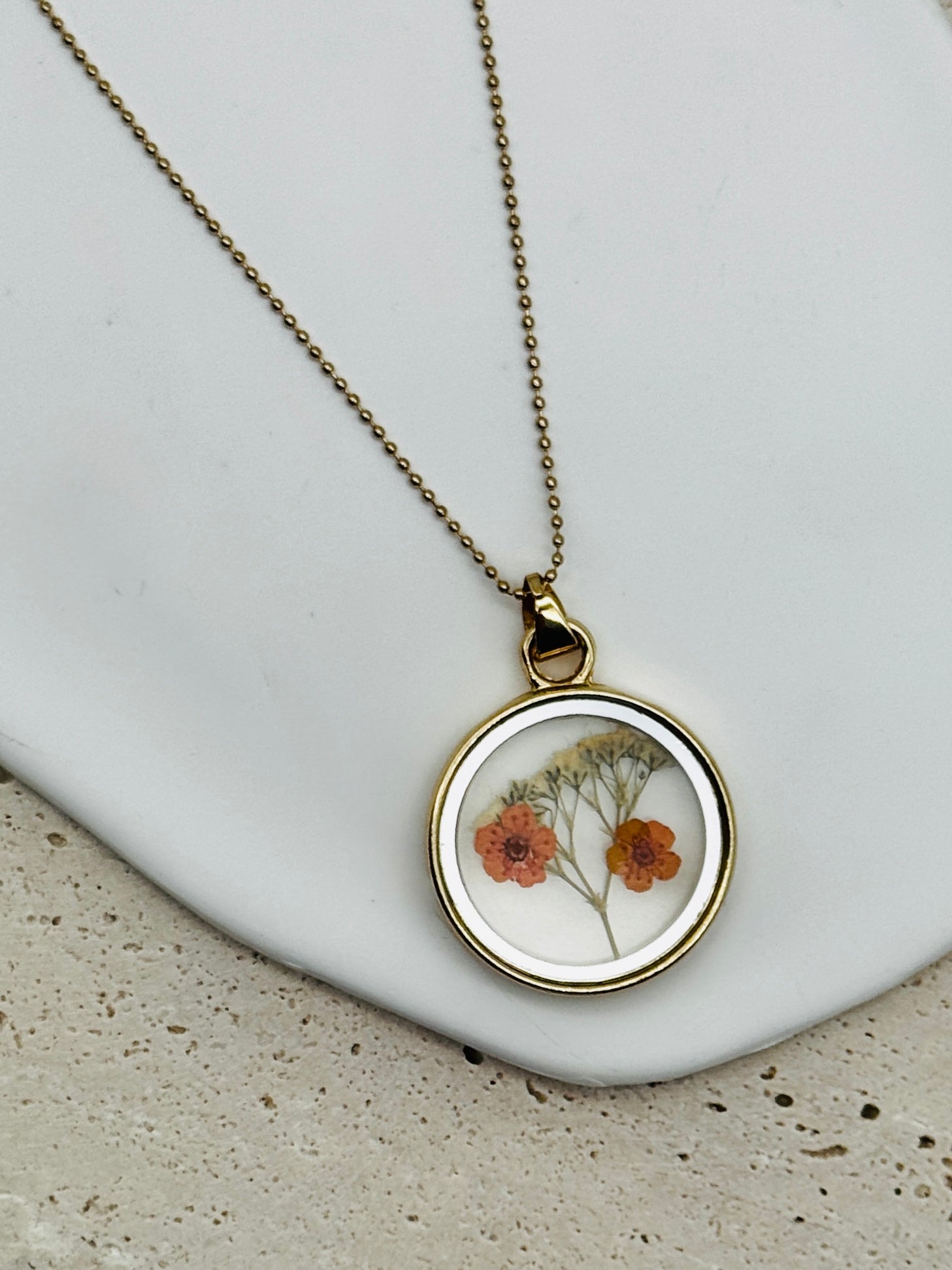 Double Sided Dry Flower Pendant Necklace with mini orange flowers inside.