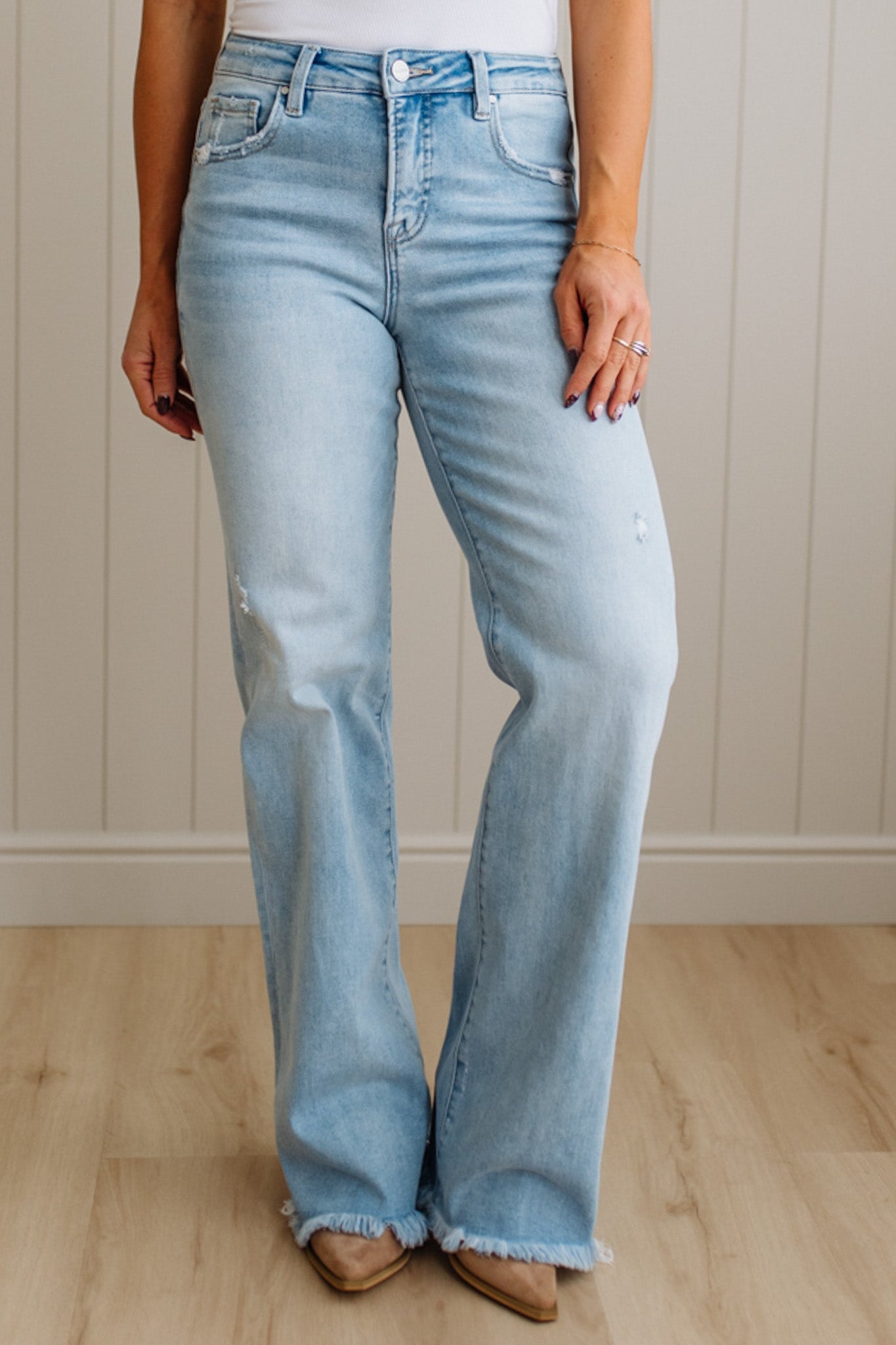 Light blue flared jeans worn by a person against a neutral background