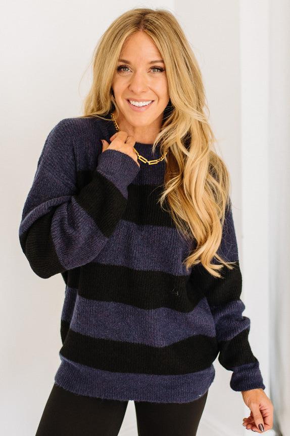 Woman wearing a blue and black striped sweater against a white background