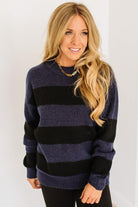 Woman wearing a black and navy striped sweater against a white background