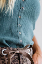 Teal knitted top with button details and leopard print pants.