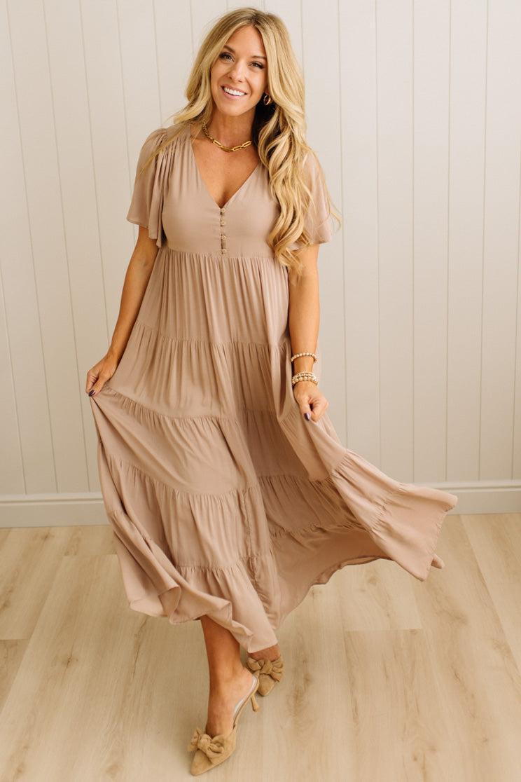 Woman wearing a beige dress with a neutral background