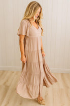 Woman wearing a long, flowing dress in a neutral setting