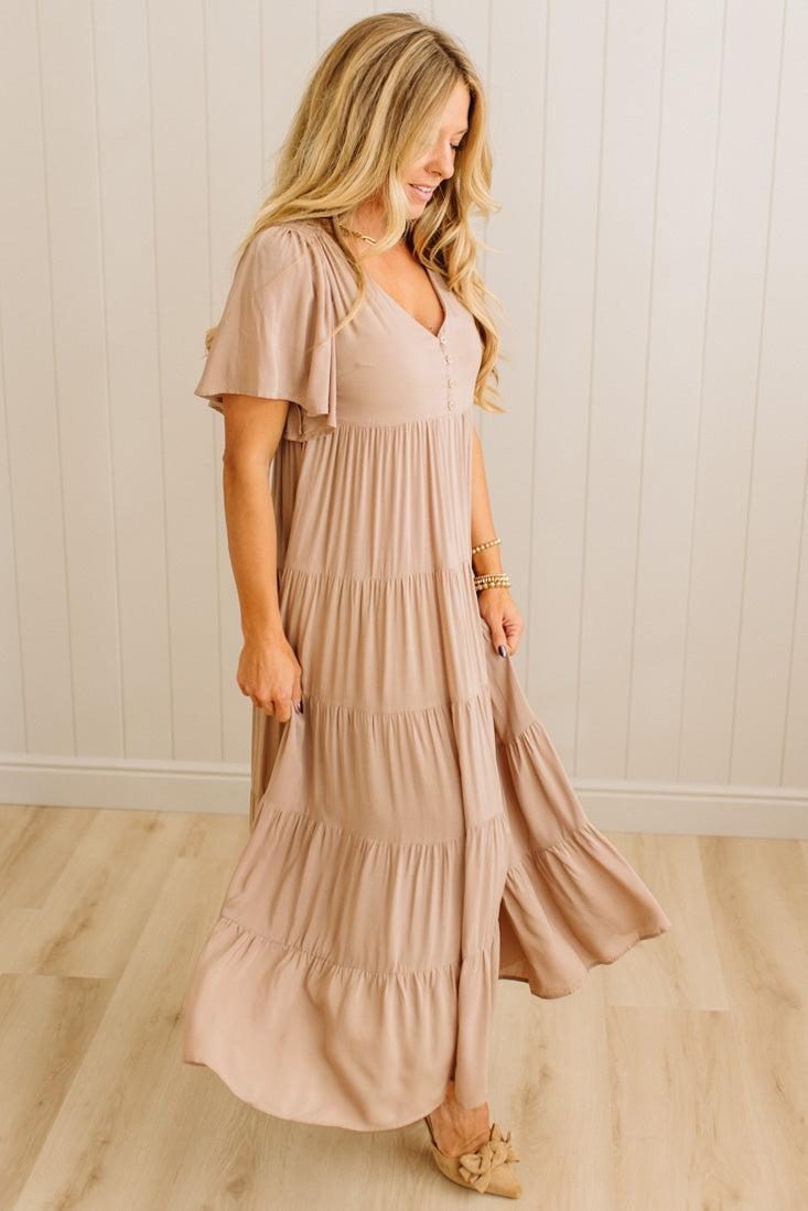 Woman wearing a long, flowing dress in a neutral setting