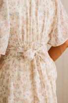 Floral dress with a tie waist on a neutral background