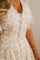 Close-up of a person wearing a floral dress with a neutral background