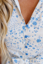 Close-up of a white blouse with blue floral patterns