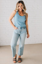 BLONDE WOMAN WEARING A ROUND NECK, SLEEVELESS, FITTED, STRIPED TANK.