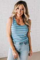 BLONDE WOMAN WEARING A ROUND NECK, SLEEVELESS, FITTED, STRIPED TANK.