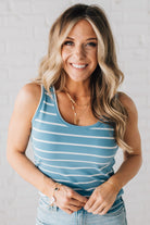 BLONDE WOMAN WEARING A ROUND NECK, SLEEVELESS, FITTED, STRIPED TANK.