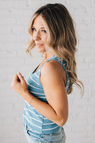 BLONDE WOMAN WEARING A ROUND NECK, SLEEVELESS, FITTED, STRIPED TANK.