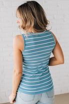 BLONDE WOMAN WEARING A ROUND NECK, SLEEVELESS, FITTED, STRIPED TANK.