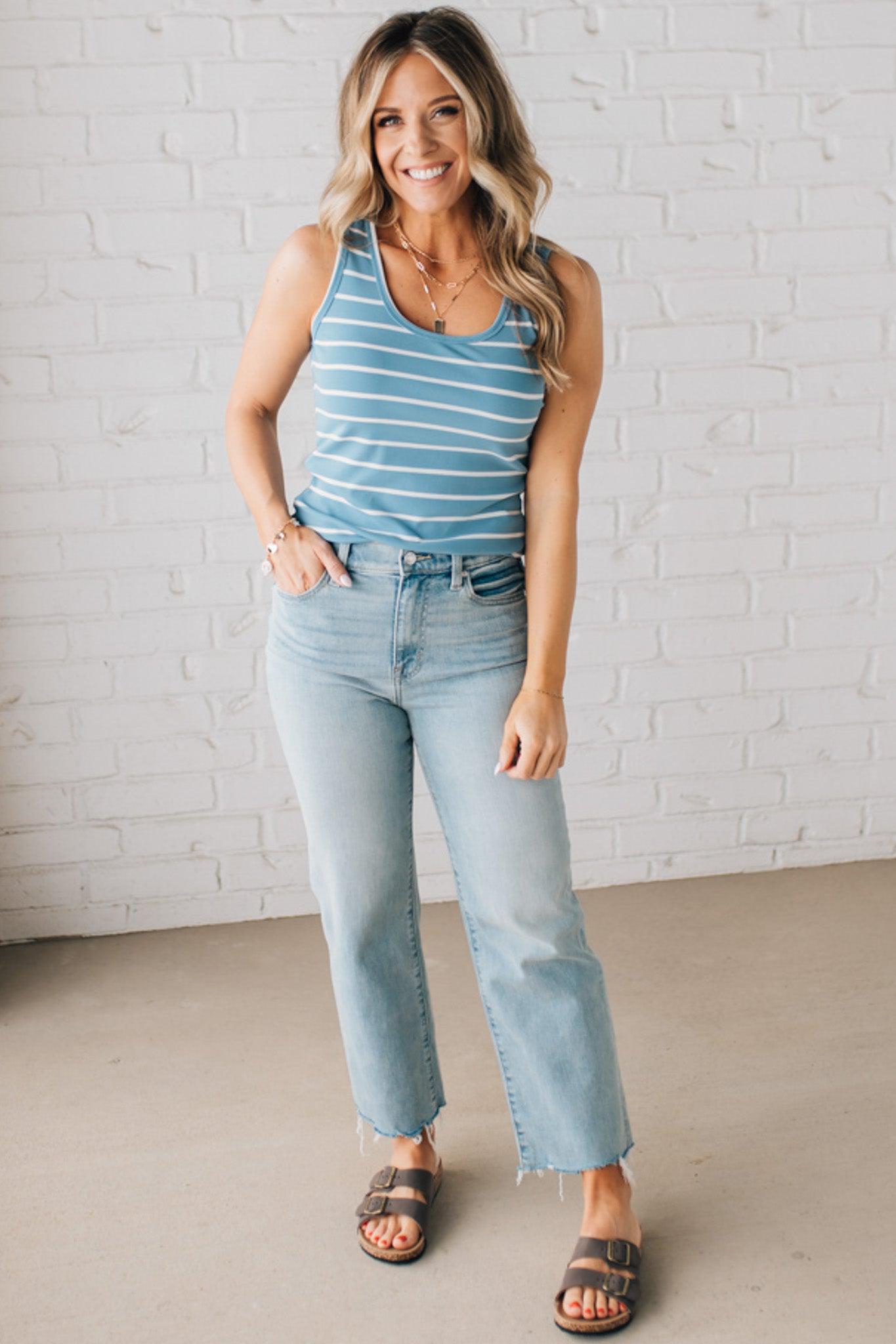 BLONDE WOMAN WEARING A ROUND NECK, SLEEVELESS, FITTED, STRIPED TANK.